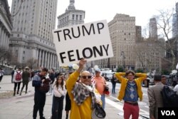 美國前總統特朗普的反對者在紐約法院外舉牌反對特朗普。（2023年4月4日）