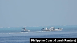 菲律賓海岸防衛隊2023年9月24日發布的拍攝於9月20日的照片顯示，中國海警船在南中國海斯卡伯勒淺灘附近的浮標屏障旁。
