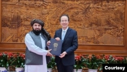 在塔利班提供的這張照片中，新任命的塔利班大使卡里米2023年12月1日在北京向中國外交部禮賓司司長洪磊遞交國書副本。
