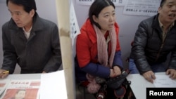 資料照片: 2016年2月23日招聘人員在中國北京招聘會上與求職者交談