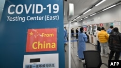 南韓檢疫工作人員在仁川國際機場COVID-19新冠疫情檢測中心引導從中國抵達的旅客。(2023 年1月3日)