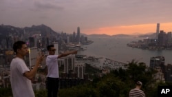 中國大陸游客在山頂拍攝香港夕照景色。(2023年4月26日)