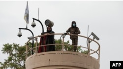 Combatientes talibanes observan desde una torre en la Embajada de EEUU durante una manifestación en Kabul, Afganistán, el 12 de abril de 2022.