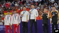 來自台灣的李洋和王齊麟站在2024巴黎奧運羽球男雙金牌頒獎台上。（2024年8月4日）
