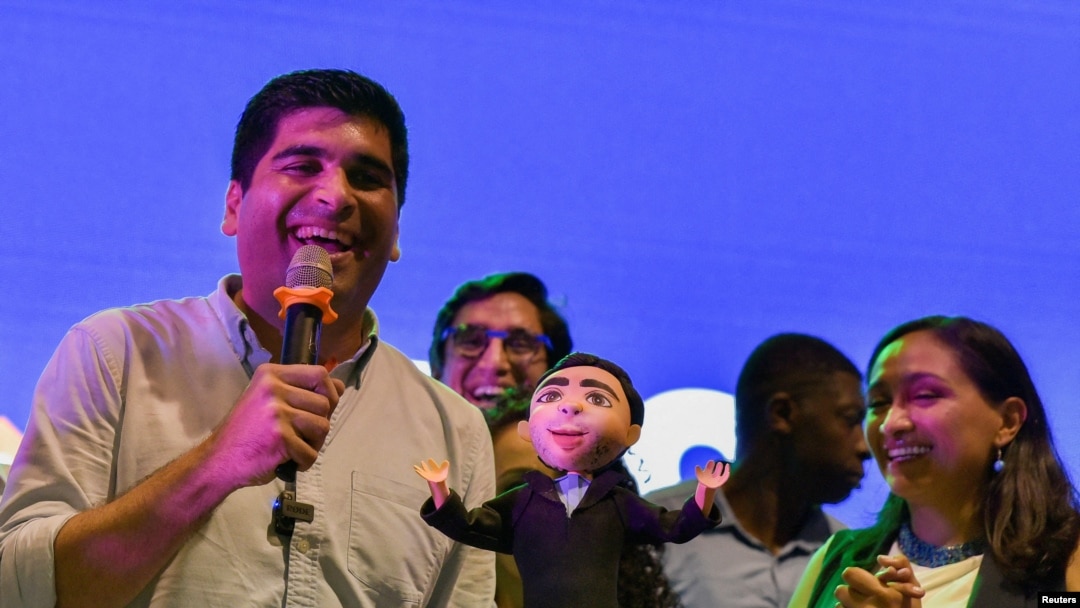 ARCHIVO - El candidato presidencial ecuatoriano Otto Sonnenholzner sostiene una muñeca que lo representa, junto a su compañera de fórmula Erika Paredes, durante su campaña de clausura, en Guayaquil, Ecuador, el 17 de agosto de 2023.