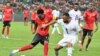 Mexer luta pela bola com o avançado do Gana, Jordan Ayew, autor dos dois golos da sua equipa, durante o jogo do grupo B do CAN 2023 entre Moçambique e Gana, no Estádio Olímpico Alassane Ouattara em Ebimpe, Abidjan, 22 janeiro 2024. (Issouf SANOGO/AFP)
