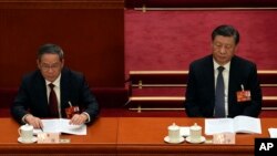 中國領導人習近平和李強在北京人大會堂出席全國人大會議。（2023年3月7日）