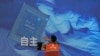 一名工人在上海舉辦的世界人工智能大會上檢查中國科技公司中科曙光展示的芯片和自主字樣的屏幕。（2023年7月5日）
