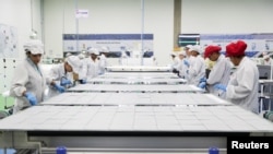 資料照：巴西工人在坎皮納斯的中國太陽能設備製造商比亞迪工廠製造太陽能板的生產線上工作。 （2020年2月13日）