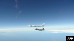 資料照片：北美防空司令部公佈的照片顯示美軍F-22“猛禽”戰鬥機攔截一架俄羅斯轟炸機。 (2020年6月16日)