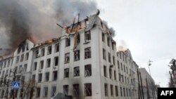 Wazimamoto wakijaribu kudhibiti moto kwenye jengo la chuo kikuu cha Karazin, mjini Kharkiv, jengo linalodaiwa kushambuliwa hivi karibuni na makombora ya Rashia. Picha ya AFP, Machi 2, 2022