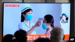 2022年5月14日，週六，在南韓首爾的一個火車站，大眾正在觀看有關北韓新冠肺炎疫情的新聞報導。