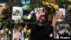 Un hombre coloca las flores en un monumento improvisado para las víctimas del colapso del condominio Champlain Torres del Sur del en Surfside en Miami, Florida, el 9 de julio de 2021.
