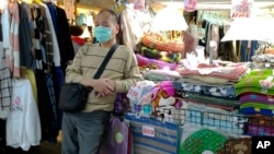 一名商販戴著口罩在台北一家夜市戴著口罩等候顧客。(2020年2月6日)