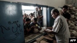 Falastinliklar BMTning G'azo sektoridagi oziq-ovqat tarqatish markazida navbat kutmoqda, 2018-yil, 8-avgust.