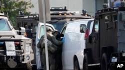 미국 경찰 특수기동대(SWAT) 대원들이 22일 캘리포니아주 토런스에서서 무차별 총격 용의자가 타고 달아난 것으로 보이는 흰색 밴 차량을 수색하고 있다.