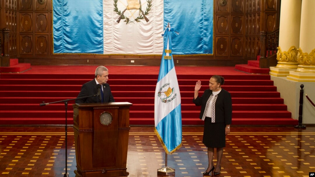 El secretario general de la Presidencia de Guatemala, Carlos Adolfo Martínez, izquierda, toma juramento a María Consuelo Porras como fiscal general dentro del Palacio Nacional en Ciudad de Guatemala, el 16 de mayo de 2018. 