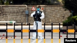 香港爆發新冠病毒期間，一名身穿個人防護裝備的中國解放軍士兵在香港的解放軍總部入口守衛。（2022年3月15日）