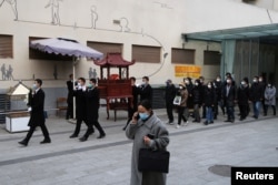 四川成都一個火葬場工作人員抬著一名逝者的骨灰盒走出火葬場。 (2022年12月28日)