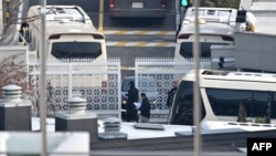 尹錫悅官邸安全人員在入口處檢查車輛；公調處正著手準備第二次的逮捕行動。 (法新社：2025年1月8日)