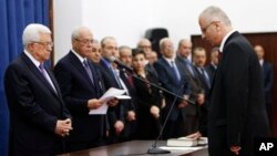 Palestinian Prime Minister elect Rami Hamdallah, right, takes oath of office in front of President Mahmoud Abbas, June 6, 2013