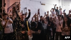 香港泛民主派支持者在一個投票站外開香檳慶祝。