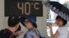폭염특보가 발령된 4일 서울 시내 한 공원에 설치된 온도계가 섭씨 40도를 나타내자 시민들이 놀란 표정을 짓고 있다. 
