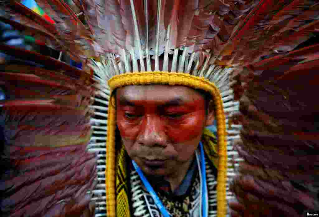 An indigenous man wearing a feathered headdress attends a climate change protest march, as the COP25 climate summit is held in Madrid, Spain.