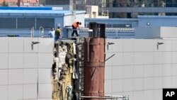 俄羅斯調查人員正在檢查據報被無人機毀壞的一個展覽館。（2023年8月18日）