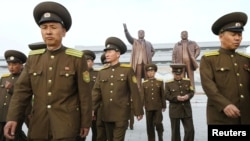 북한 인민군 창건 85주년을 맞은 25일, 군인들이 평양 만수대 언덕의 김일성, 김정일 동상에 헌화한 후 돌아가고 있다.