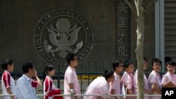 Estudiantes chinos esperan en el exterior de la embajada de EE.UU. en Beijing para obtener una visa de estudiante extranjero.