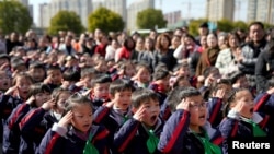 資料照：中國上海一所小學的學生們在新學期第一天舉行的升旗儀式上敬禮。 (2018年2月23日)