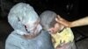 This citizen journalism image taken on April 25, 2013 and provided by Edlib News Network (which has been authenticated) shows a wounded Syrian man holding his injured son after an air raid on the town of Saraqeb in Idlib province.