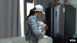 中國媽媽“小”(化名)抱著她2024年底在塞班島產下的女兒。 (美國之音拍攝)