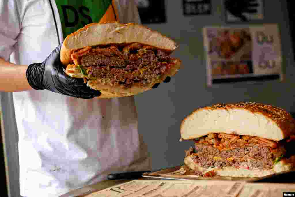 A chef holds up what it is believed to be Thailand's biggest burger weighing more than 6 kilograms, before a competition held to eat it, at the Chris Steaks & Burgers restaurant in Bangkok.