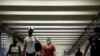 People wear masks as they pass through a pedestrian subway as cases of the infectious coronavirus Delta variant continue to rise in New York City, New York