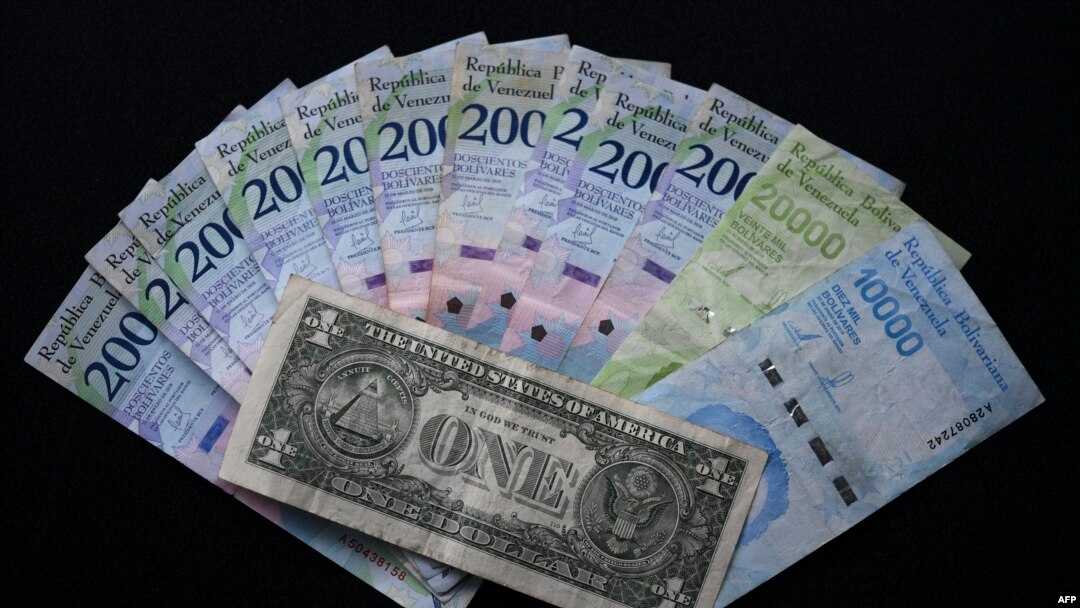 Imagen de un billete de un dólar y su equivalente promedio en la divisa venezolana (32.000 bolívares).