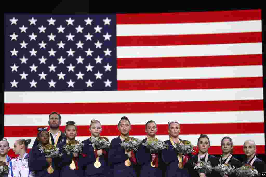 Team U.S.A. listens to the national anthem after winning the gold medal in the women's team final at the Gymnastics World Championships in Stuttgart, Germany.