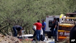 ARCHIVO - Los forenses trabajan sobre los cadáveres en el lugar de un accidente de autobús al costado de la carretera cerca de Villa de Tepelmeme, estado de Oaxaca, México, el viernes 6 de octubre de 2023. 