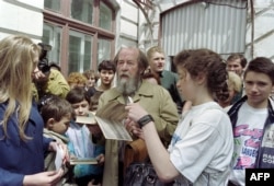 Russian writer Alexander Solzhenitsyn autographs his book "Archipelago GULAG" after meeting pupils of school number 1 in Vladivostok on May 30, 1994.