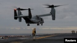 FILE - A U.S. Marines MV-22 Osprey Aircraft lands on the deck of the USS Bonhomme Richard amphibious assault ship off the coast of Sydney, Australia, June 29, 2017. 