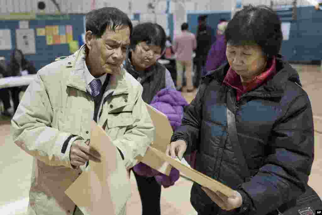 Zhou Nan Zhou, e a sua mulher, Li Li Tan, preparando-se para escolher os seus candidatos em Brooklyn, Nova Iorque.