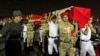 The caskets of 25 policemen killed early Monday morning near the north Sinai town of Rafah are carried after arriving at Almaza military airport in Cairo August 19, 2013. 