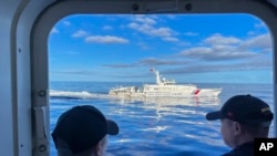 一艘中國海警船在南中國海第二托馬斯淺灘（Second Thomas Shoal，中國稱仁愛礁）附近干擾菲律賓海岸警衛隊運輸船隻。（美聯社）
