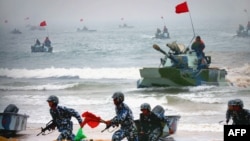 中國解放軍兩棲坦克與士兵參加在山東舉行的登陸軍演。（2005年8月24日）