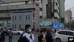 资料照片：人們走過新疆首府烏魯木齊的一處警察站。 (2021年4月21日)