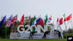 2023 年 7 月 13 日，在印度古吉拉特邦首府甘地訥格爾，工人趕在G20峰會的一個工作組會議前安裝峰會的標誌。