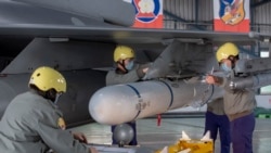 台灣嘉義一個空軍基地的地勤人員在一架F-16戰機的機翼上安裝飛彈。 （2023年1月6日）