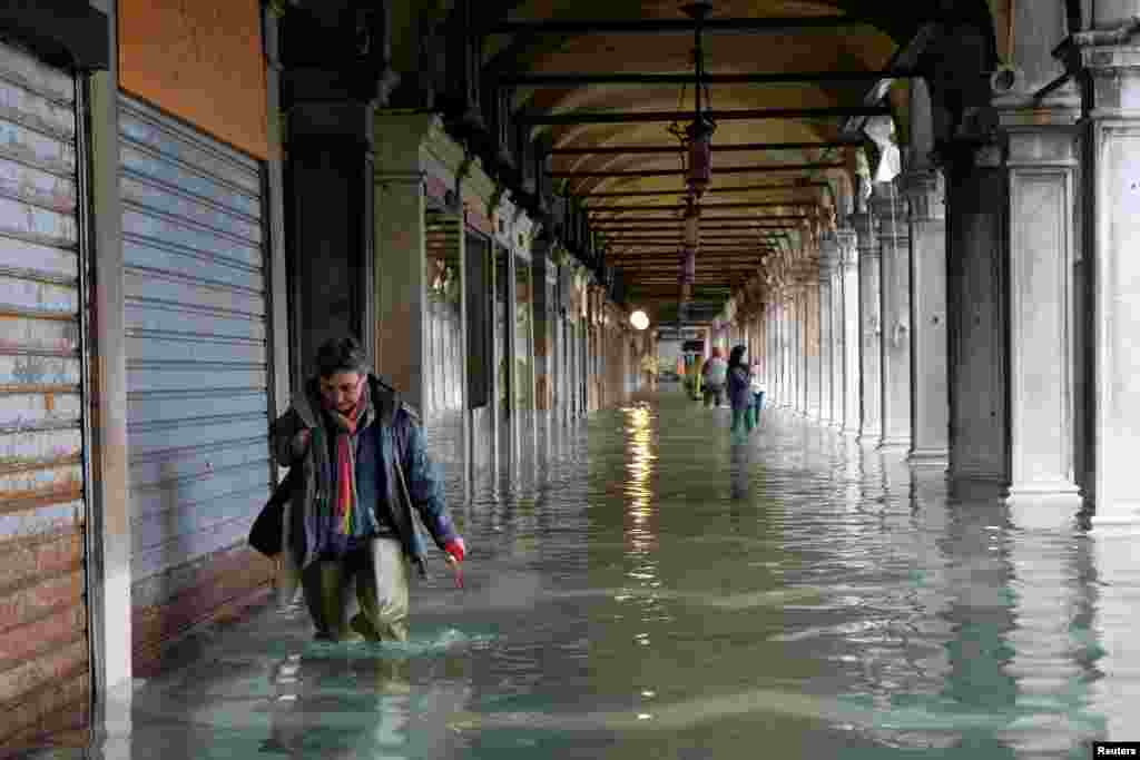 A woman walks in the flooded St. Mark's Square during a period of seasonal high water in Venice, Italy.