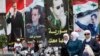 Ahead of Tuesday's election, women walk past election posters of Syria's President Bashar al-Assad along a street in Damascus, Syria, June 2, 2014. 